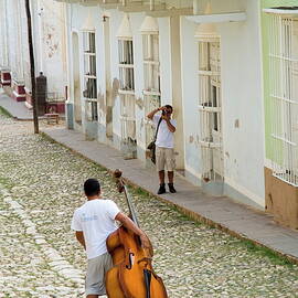Cuban man carrying a cello by Sami Sarkis Photography