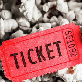 Event ticket lying on pile of popcorn by Jorgo Photography