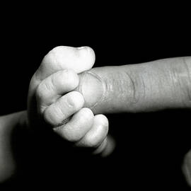 Father's finger touching his baby's foot by Sami Sarkis Photography