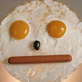 Fried breakfast of eggs and sausage made into a neutral face by Sami Sarkis Photography