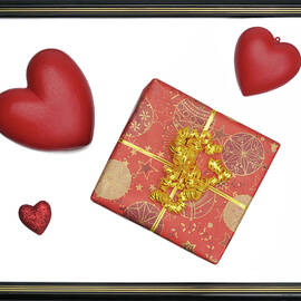 Gift box and heart-shaped objects in picture frame by Sami Sarkis Photography