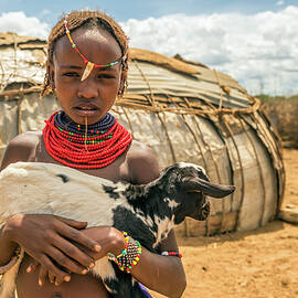 Girl from the African tribe Dasanesh holding a goat by Miroslav Liska