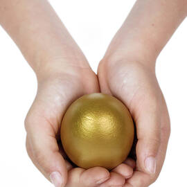 Girl holding golden egg in hands by Sami Sarkis Photography
