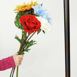 Hand of girl holding flowers over empty picture frame by Sami Sarkis Photography