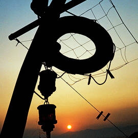 Lifebuoy silhouetted on a fishing boat at sunset by Sami Sarkis Photography