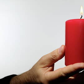 Man holding burning candle by Sami Sarkis Photography