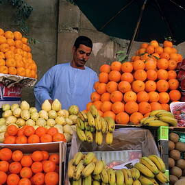 Market vendor selling fruit in a bazaar by Sami Sarkis Photography