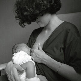 Mother breastfeeding her newborn baby boy by Sami Sarkis Photography