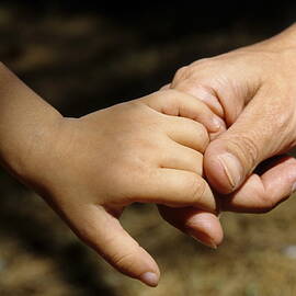 Mother holding baby daughter's hand by Sami Sarkis Photography