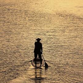 Old man paddling into the sunset by M C Hood