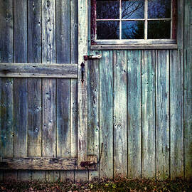 Old shed door with spooky shadow in window by Sandra Cunningham