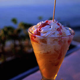 Peach ice cream sundae served with a cocktail umbrella in a glass by Sami Sarkis Photography