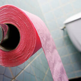 Pink toilet roll on holder in bathroom by Sami Sarkis Photography