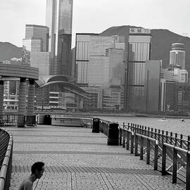 Seated man practicing yoga with view of skyline in the background by Sami Sarkis Photography