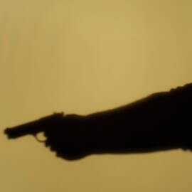Shadow of man pointing gun by Sami Sarkis Photography
