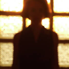 Silhouette of a woman standing in front of a window by Sami Sarkis Photography