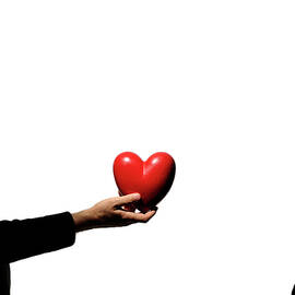 Silhouette of couple standing face to face man holding heartshaped object by Sami Sarkis Photography