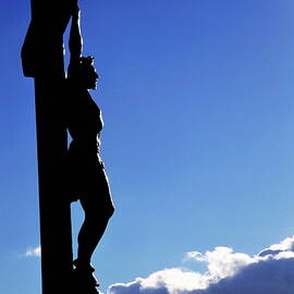 Statue of Jesus Christ on the cross against a cloudy sky by Sami Sarkis Photography