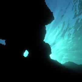 Sunbeams and holes in underwater cave by Sami Sarkis Photography