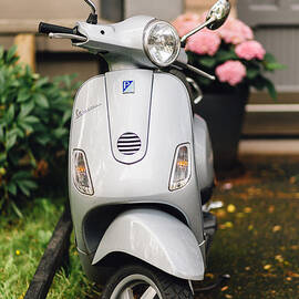 Vintage grey Vespa,old fashioned Italian motorbike, is parked on the street sideway by Aldona Sate