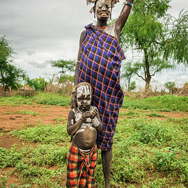 Woman from the african tribe Mursi with her baby, Ethiopia by Miroslav Liska