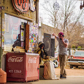 Young man uses a vintage telephone at a retro gas station by Miroslav Liska
