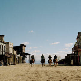 Cowboys Riding Horses Through Town by Matthias Clamer