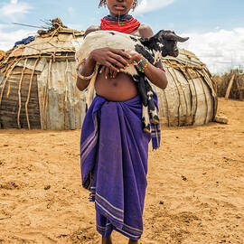 Girl from the African tribe Dasanesh holding a goat by Miroslav Liska