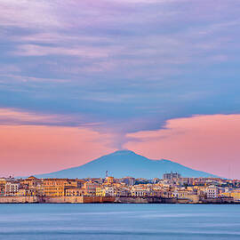 Italy, Sicily, Siracusa District, Ionian Coast, Mediterranean Sea, Ionian Sea, Siracsyracuse And The Etna Volcano Erupting In The Background Seen From The Plemmirio Protected Marine Area by Luca Scamporlino
