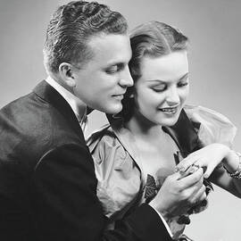 Man Putting Ring On Womans Finger by George Marks