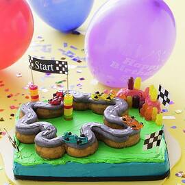 A Child's Birthday Cake a Racing Track And Balloons by Young, Andrew