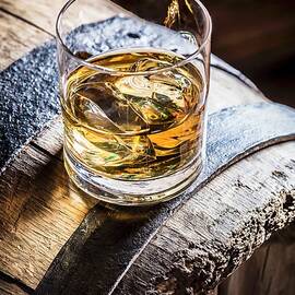 A Glass Of Whiskey With Ice On An Old Wooden Barrel by Shaiith