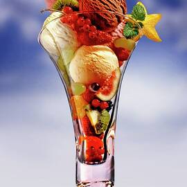 An Ice Cream Sundae With Fresh Fruits Against A Cloudy Sky by Bodo A. Schieren
