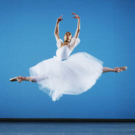 Ballerina Leaping On Stage, Arms Raised by Thomas Barwick