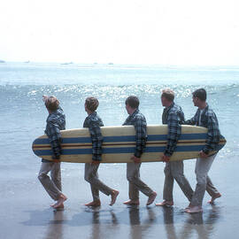 Beach Boys On The Beach With A Surfboard Art Print by Michael Ochs