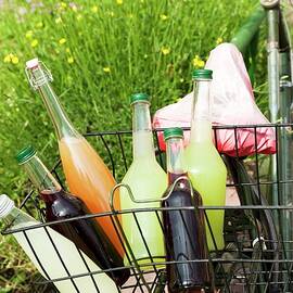 Bottles Of Various Homemade Lemonades In A Bike Basket by Manuela Rüther