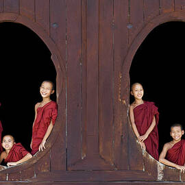 Buddhist Monks In Window Of Monastery by Martin Puddy