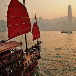 China, Hong Kong, Hong Kong Island, Victoria Harbor, Traditional Junk In The Victoria Harbor With The International Finance Center And The City Skyline In The Background by Luigi Vaccarella