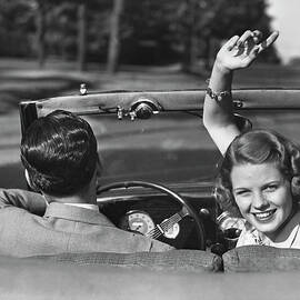 Couple Driving In Convertible by George Marks