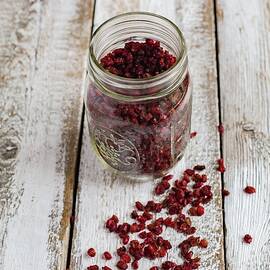 Dried Goji Berries In A Glass Jar On A Wooden Background by Tina Engel