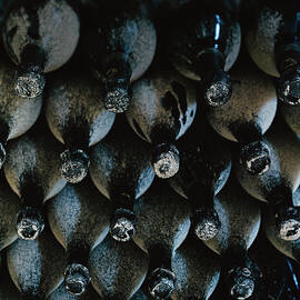 Dust Covered Bottles Of Wine by Romulo Yanes