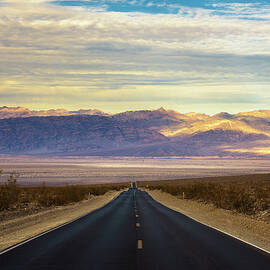 Empty road running through Death Valley by Miroslav Liska