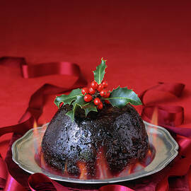 English Christmas Pudding With Flames And Holly Garnish On Pewter Plate by Michael Paul