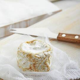 Goat's Cheese On A Muslin Cloth With A Cheese Knife Next To It by Miriam Rapado