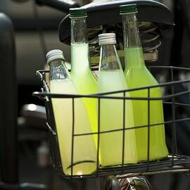 Homemade Cucumber And Lemonade In Bottles In A Bike Basket by Manuela Rüther
