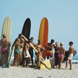 People On Beach With Surf Board by Tom Kelley Archive