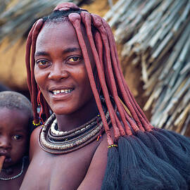 Portrait of a young himba woman with her child wearing traditional hairstyle by Miroslav Liska