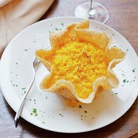 Saffron Risotto In A Parmesan Basket And A Glass Of Red Wine by Anthony Lanneretonne