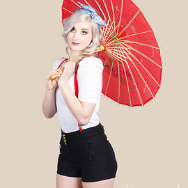 Smiling retro woman holding a red umbrella  by Jorgo Photography