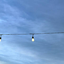 String Of Lightbulbs Against A Cloudy by 2ndlookgraphics